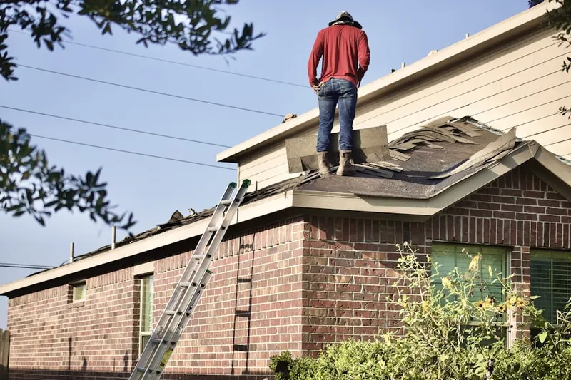 Professional roofer working on a residential roof in Village West